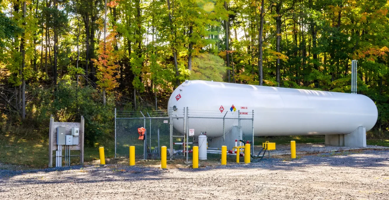 Citerne professionnelle de gaz propane installée à l'extérieur d'un établissement commercial français avec technicien effectuant une inspection
